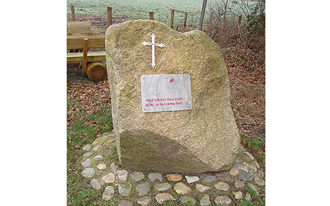 Stein mit einem Kreuz und einem Schild mit der Aufschrift: 